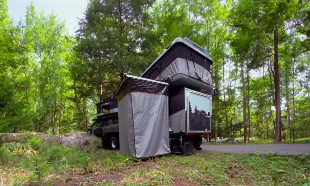 Falcon Shower and Rooftop Tent Seamlessly Attached on a Trailer Amidst the Forest