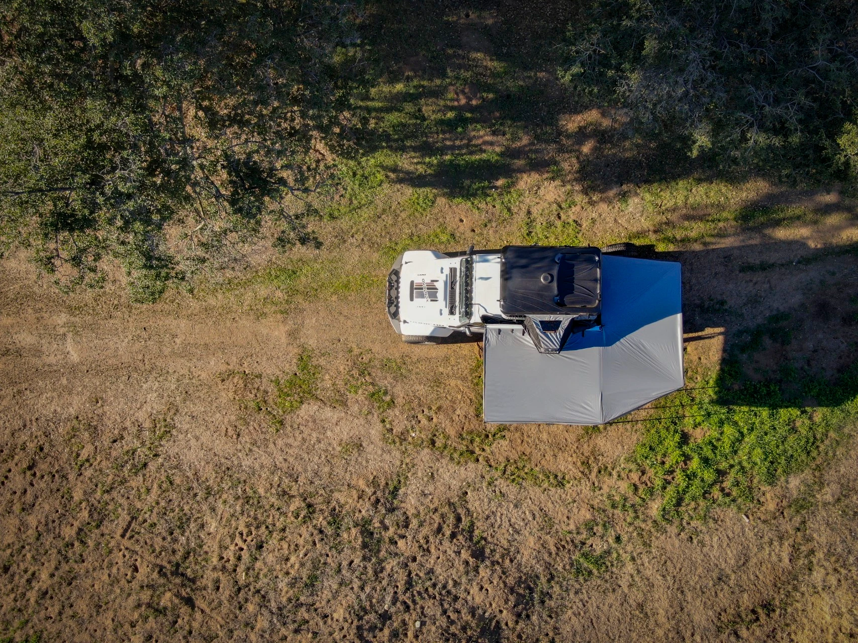 A car with a james baroud 270 falcon awning parked in the grass view from top