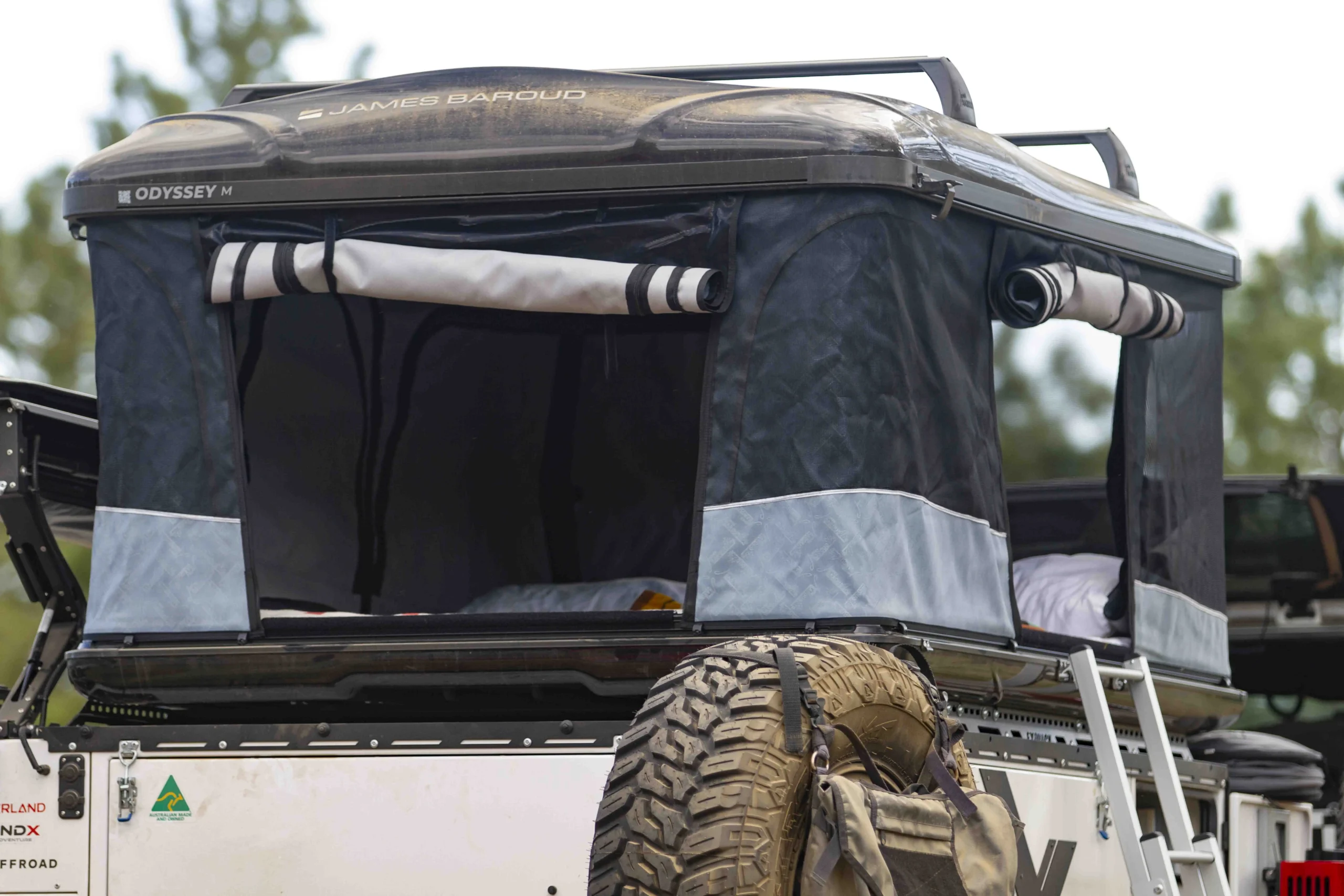 A car parked by the lake with a simple awning installed on the car