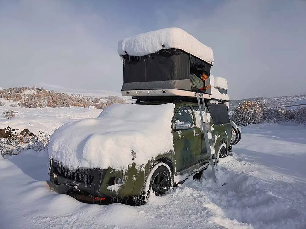 snow piled on top of hardsheel rooftop tent 