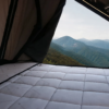 James Baroud TBS bedding system inside a rooftop tent with mountain view