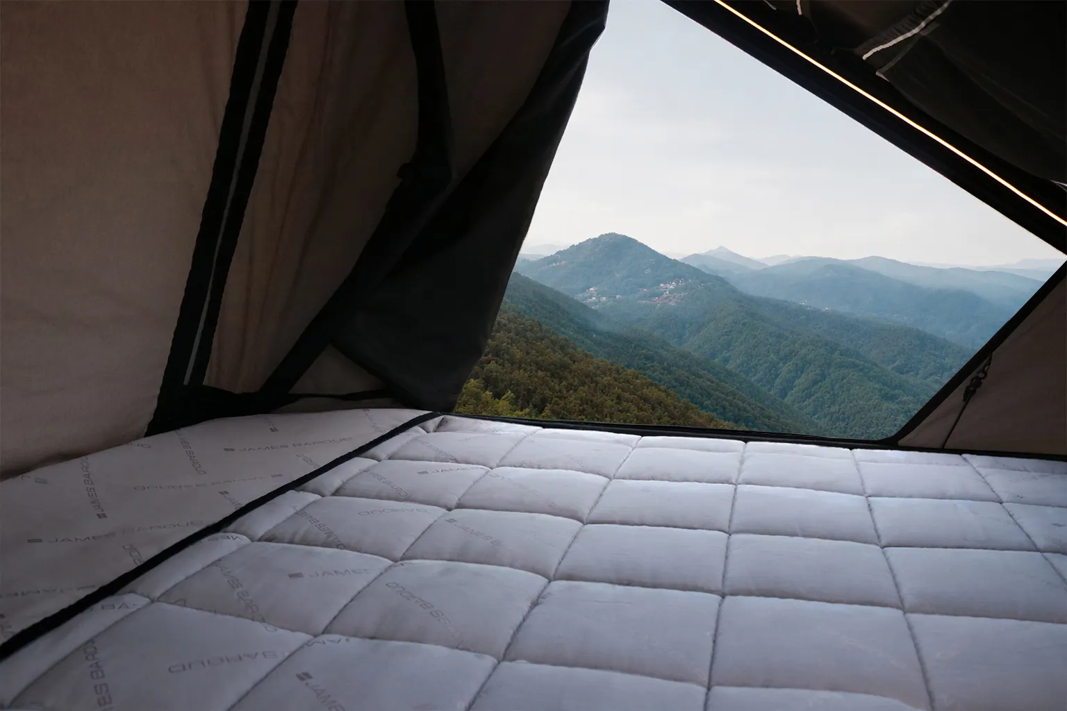 James Baroud TBS bedding system inside a rooftop tent with mountain view