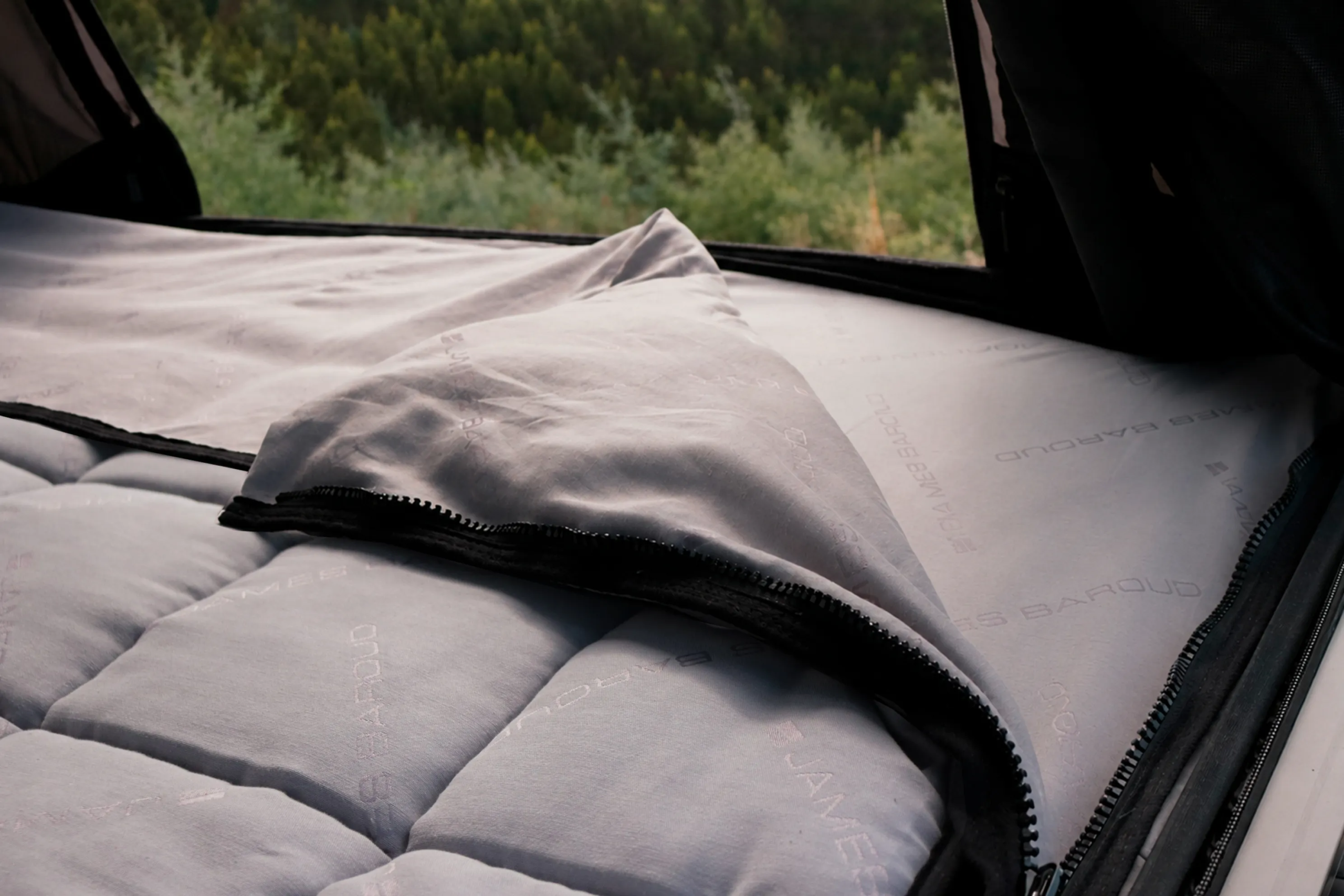 James Baroud TBS bedding system partially opened inside a rooftop tent